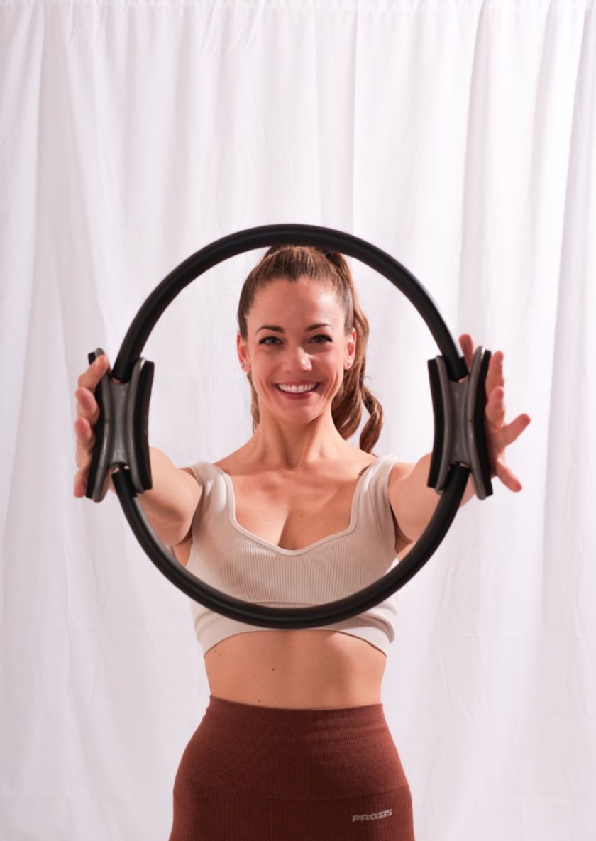 Alessandra Marinuzzi sorride e tiene il cerchio da pilates a braccia tese
